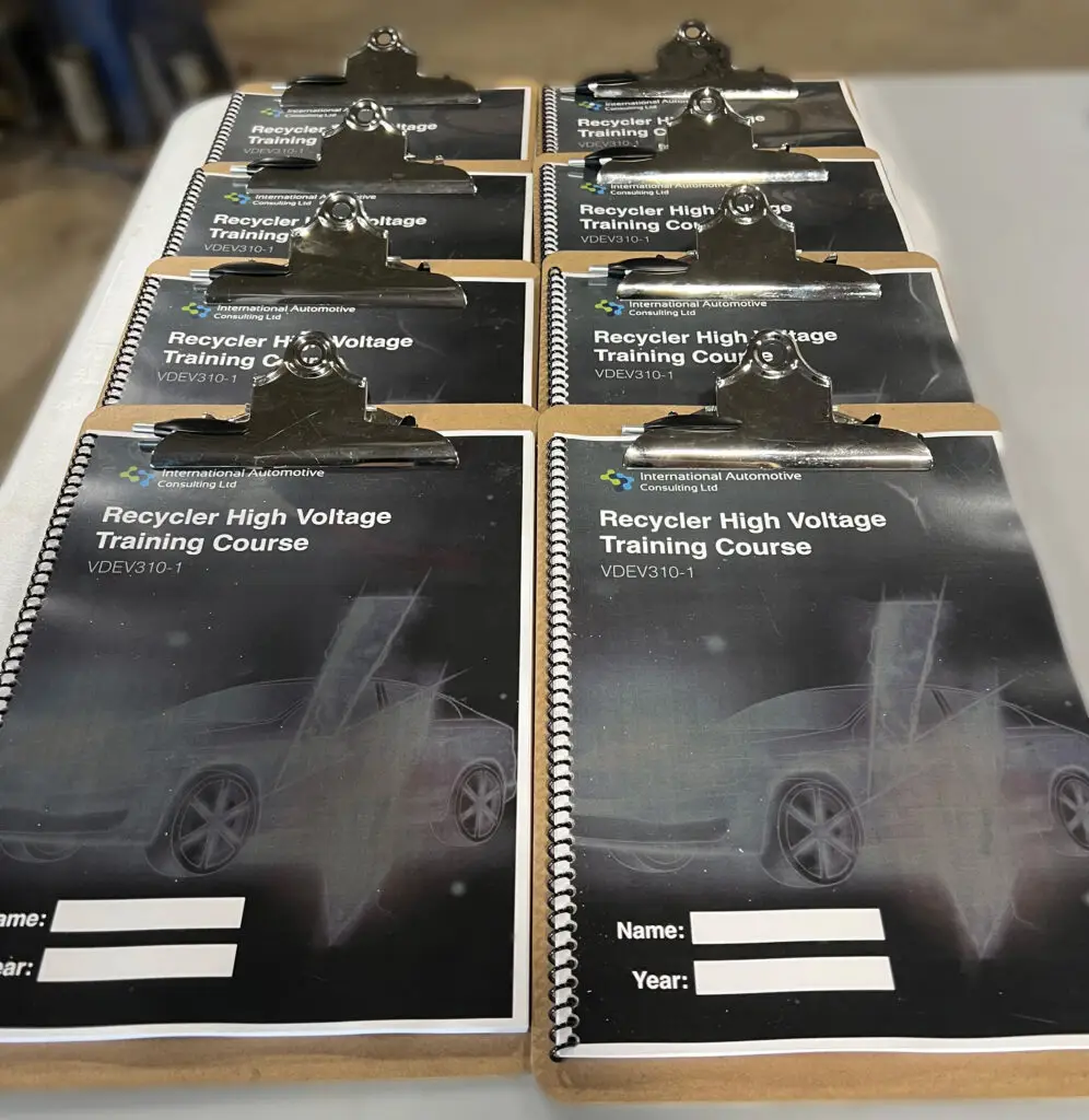 Clipboards with course materials lined up on a table.